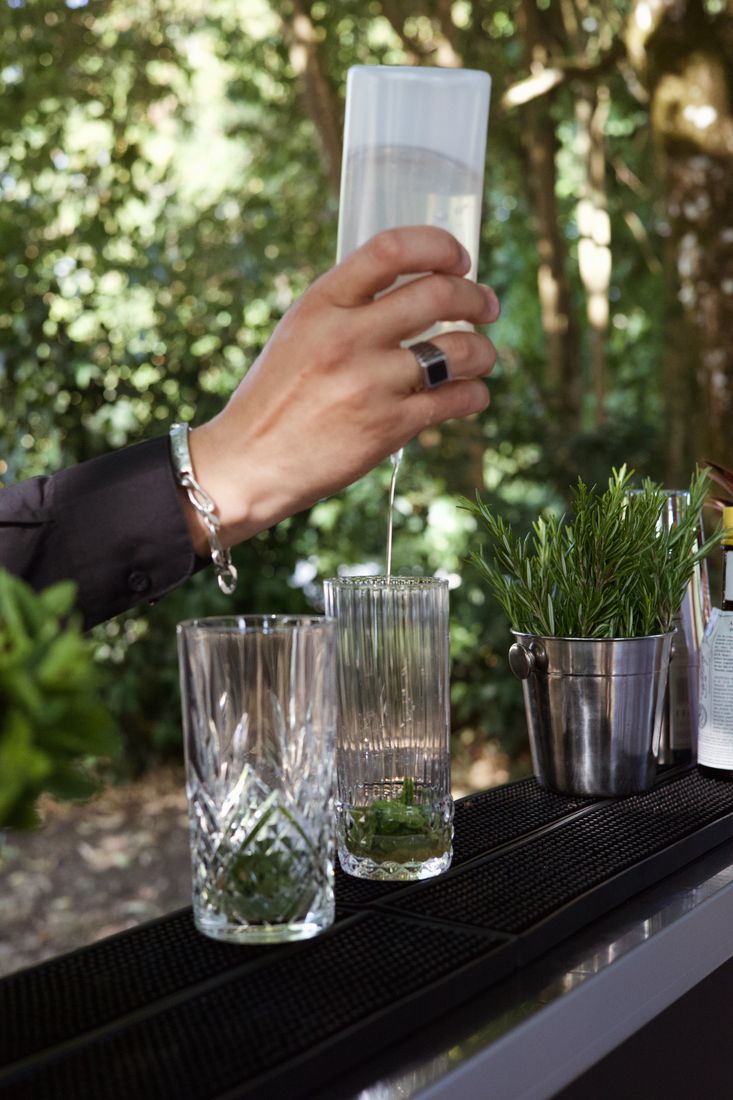 Verrerie et ingrédients frais alignés sur le comptoir du bar à cocktails