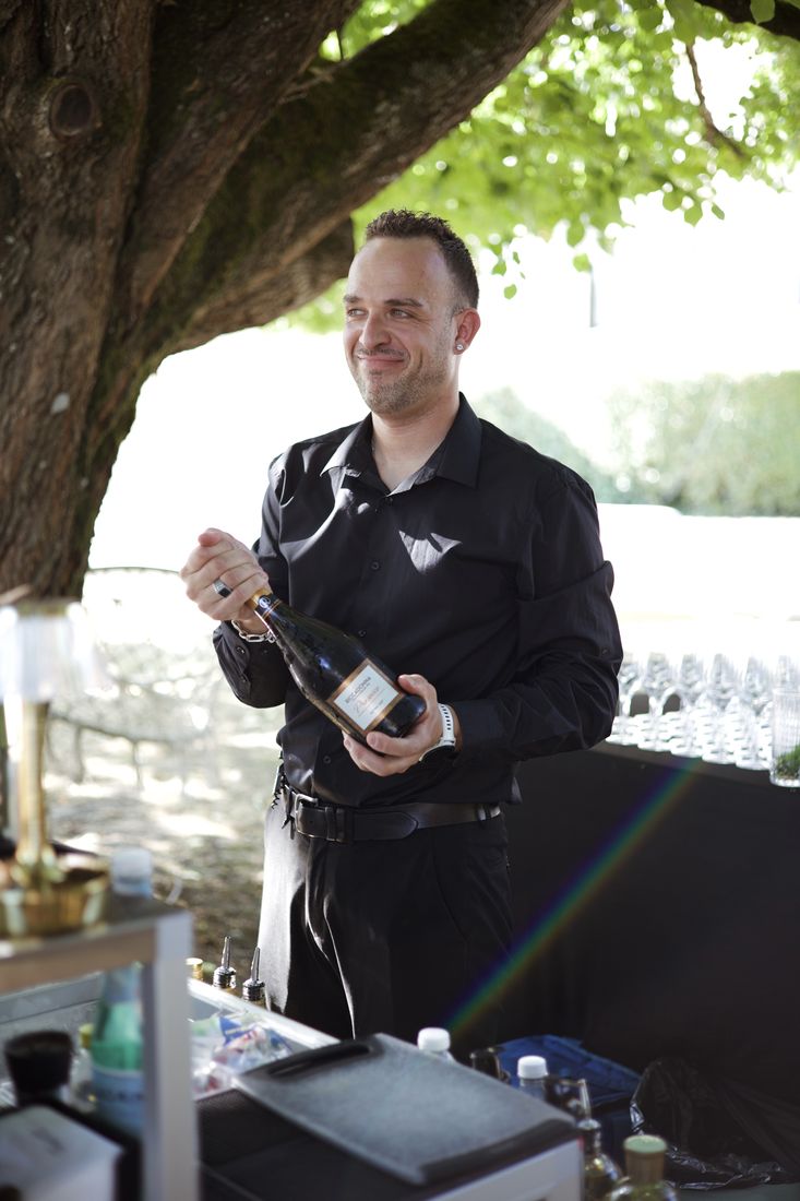 Barman finalisant un cocktail devant les invités du mariage