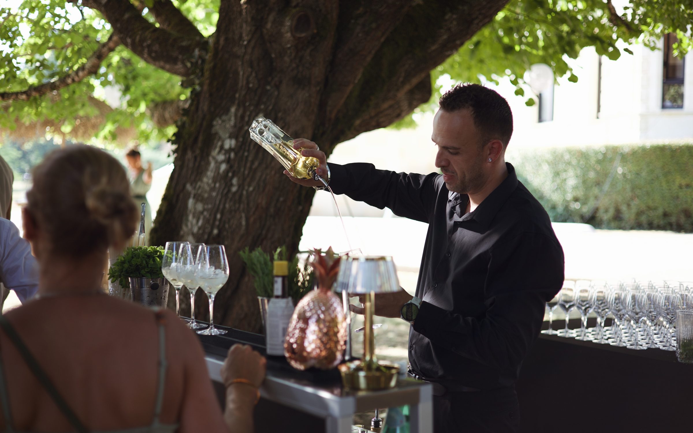 Bar à cocktails éphémère Dassonville installé sous les arbres lors d'un mariage en Gironde